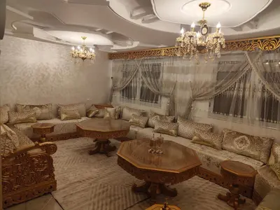a living room with a couch and tables and a chandelier at Modern suite BJ in Boujad