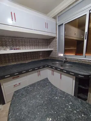 a kitchen with white cabinets and a sink at Modern suite BJ in Boujad
