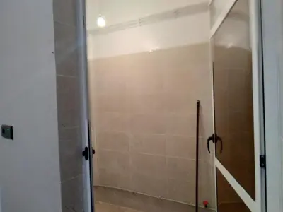 a shower with a glass door in a bathroom at Appartement Chez issmail in Tinerhir