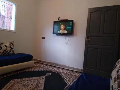 a tv on a wall in a room with a door at Appartement Chez issmail in Tinerhir