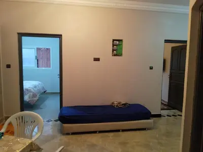 a room with a bed and a bedroom with a door at Appartement Chez issmail in Tinerhir