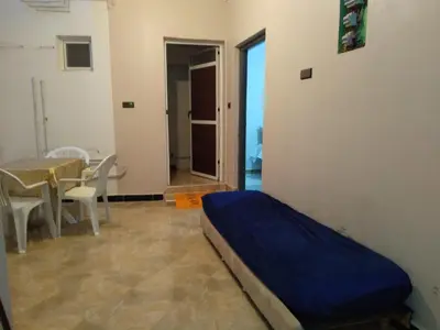 a bedroom with a bed and a table and chairs at Appartement Chez issmail in Tinerhir