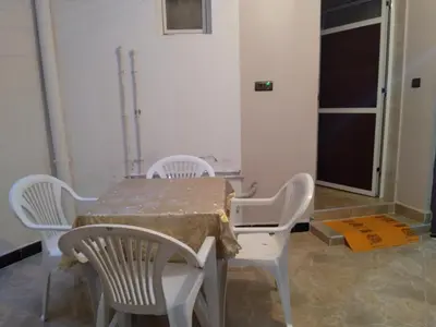 a table and chairs in a room with a table and a window at Appartement Chez issmail in Tinerhir