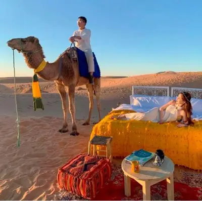a man and a woman on a camel in the desert at Une Nuit de Rêve dans une Tente de Luxe - Expérience en plein désert ! in Merzouga