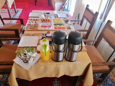 a table with two tables with food and drinks at Une Nuit de Rêve dans une Tente de Luxe - Expérience en plein désert ! in Merzouga