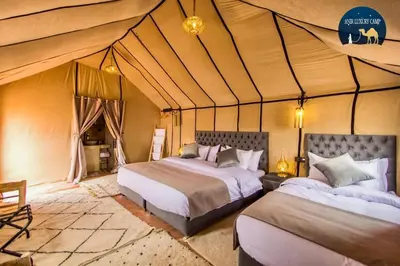 a bedroom with two beds in a tent at Une Nuit de Rêve dans une Tente de Luxe - Expérience en plein désert ! in Merzouga