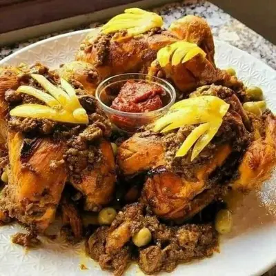 a plate of food with chicken with sauce on it at Hôtel La Vallée Des Oiseaux in Boumalne
