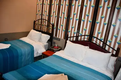 a room with two beds and a striped wall at Hôtel La Vallée Des Oiseaux in Boumalne