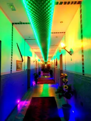a hallway with purple and green lights in a building at Hôtel La Vallée Des Oiseaux in Boumalne