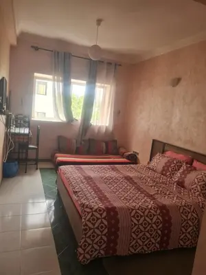 a hotel room with two beds and a window at chamber chez l habitant pour les femmes à côté CTM & Gare du train in Fès