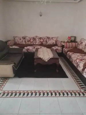 a living room with a couch and a coffee table at chamber chez l habitant pour les femmes à côté CTM & Gare du train in Fès
