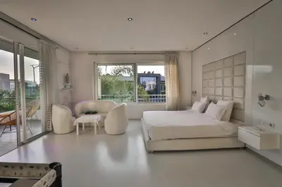 a white bedroom with a bed and a table and chairs at Villa familiale moderne avec piscine in Fès