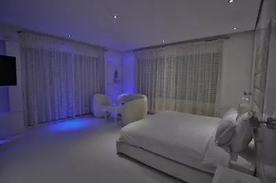 a bedroom with a white bed and a purple lighting at Villa familiale moderne avec piscine in Fès
