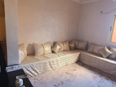 a couch in a room with gold pillows on it at Ramz Appartement in Beni Mellal