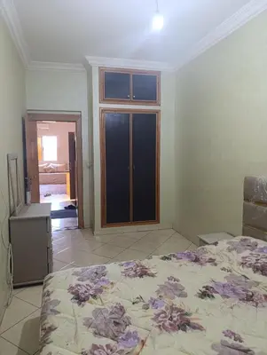 a bedroom with a bed and a large window at Ramz Appartement in Beni Mellal
