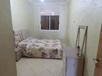 a small bedroom with a bed and a window at Ramz Appartement in Beni Mellal