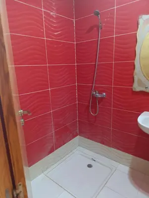 a bathroom with a shower with red tiles at Ramz Appartement in Beni Mellal