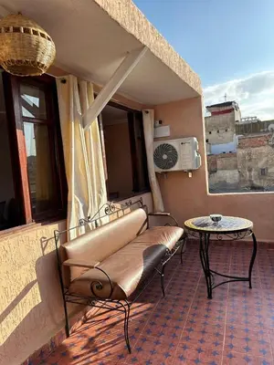 a balcony with a bench and a table on a building at House andalous in Fès