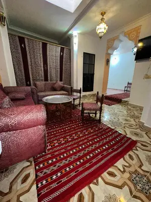 a living room with a couch and a table and a rug at House andalous in Fès