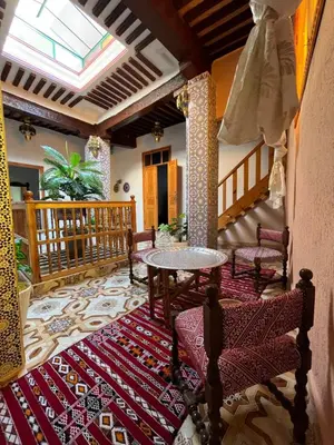 a living room with a table and chairs on a rug at House andalous in Fès