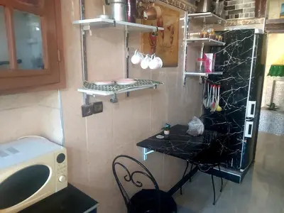 a small kitchen with a black table and a counter at Air house in Gare de Meknès