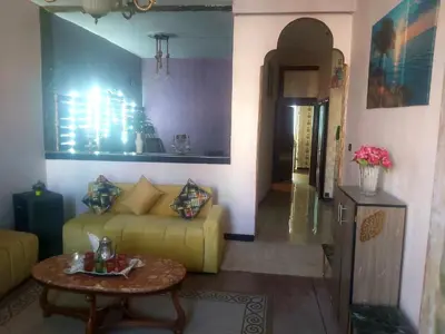 a living room with a yellow couch and a table at Air house in Gare de Meknès