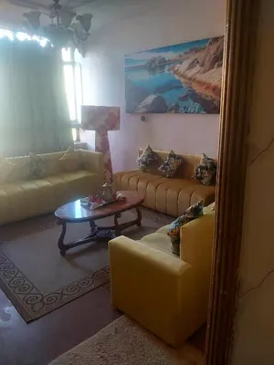 a living room with yellow couches and a table at Air house in Gare de Meknès