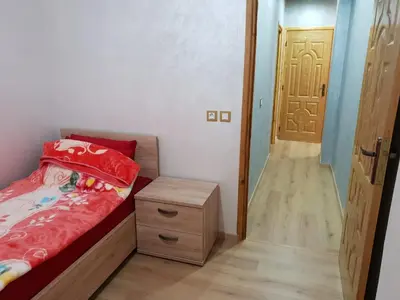 a small bedroom with a bed and a wooden door at Welcome1 in Meknès