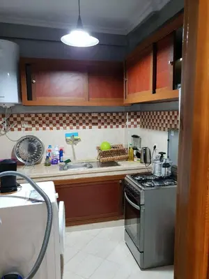 a kitchen with wooden cabinets and a stove top oven at Welcome1 in Meknès