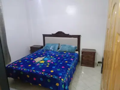 a bedroom with a bed with a blue comforter at Welcome1 in Meknès