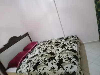 a bedroom with a bed with a black and white comforter at Welcome1 in Meknès