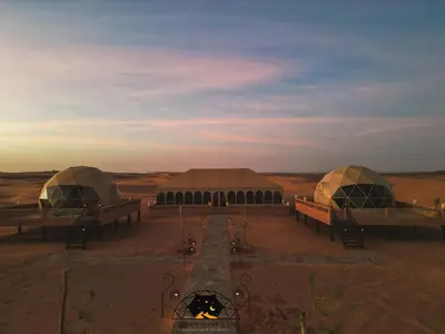 two domes in the middle of a desert at Royal Sahara Dome Camp in Merzouga