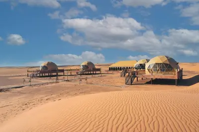 a group of tents in the middle of the desert at Royal Sahara Dome Camp in Merzouga