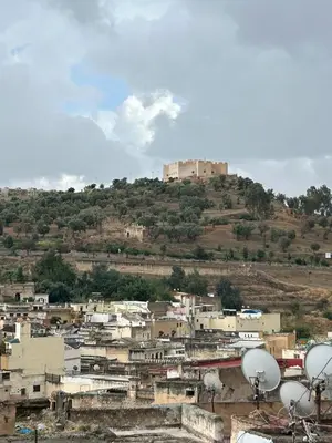 a city with a castle on top of a hill at DarMouniaFès in Fès