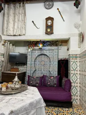 a living room with a purple couch and a clock at DarMouniaFès in Fès