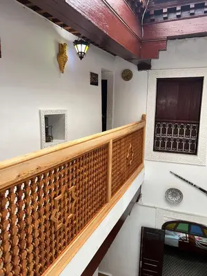 a stairway with a wooden railing and a window at DarMouniaFès in Fès