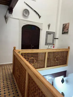 a wooden staircase with a brown door and a clock on the wall at DarMouniaFès in Fès