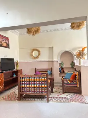 a living room with two chairs and a tv at Apparemment de luxe avec terrasse privée in Zagora