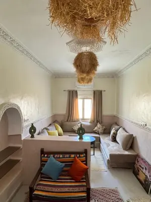 a living room with a couch and a chandelier at Apparemment de luxe avec terrasse privée in Zagora