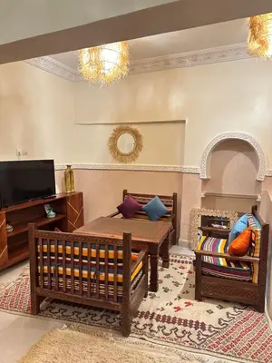 a living room with a table and a tv at Apparemment de luxe avec terrasse privée in Zagora