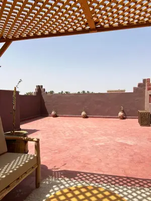 a view of a patio with a wooden pergola at Apparemment de luxe avec terrasse privée in Zagora