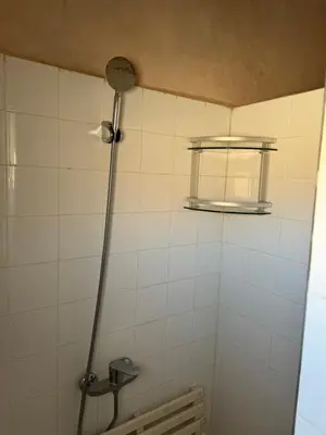 a shower in a white tiled bathroom with a window at Apparemment de luxe avec terrasse privée in Zagora