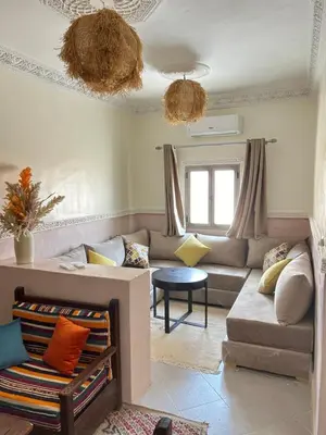 a living room with a couch and a table at Apparemment de luxe avec terrasse privée in Zagora