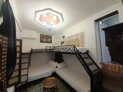 a room with two bunk beds and a couch at Dar Lalla Wafae in Fès