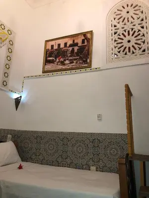 a bedroom with a bed and a picture on the wall at Dar Lalla Wafae in Fès