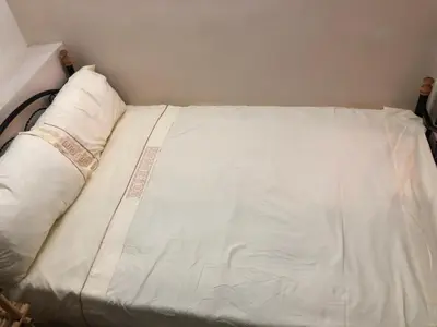 a bed with white sheets and pillows in a room at Dar Lalla Wafae in Fès