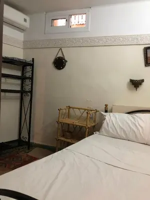 a bedroom with a white bed and a window at Dar Lalla Wafae in Fès