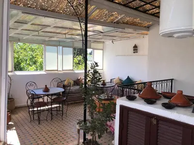 a patio with a table and chairs and a table and some windows at Dar Lalla Wafae in Fès
