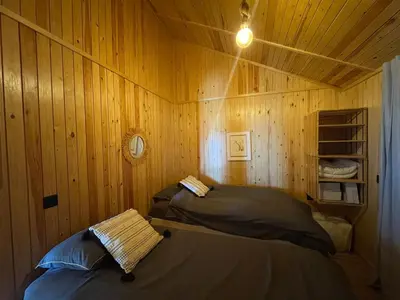 a bedroom with two beds in a wooden wall at Scandinavian Chalet in the Atlas Mountains - Ifrane in Ifrane