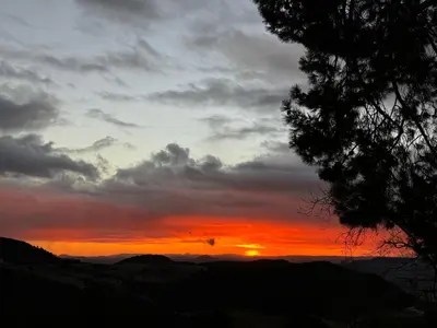 a sunset with the sun setting in the sky at Scandinavian Chalet in the Atlas Mountains - Ifrane in Ifrane